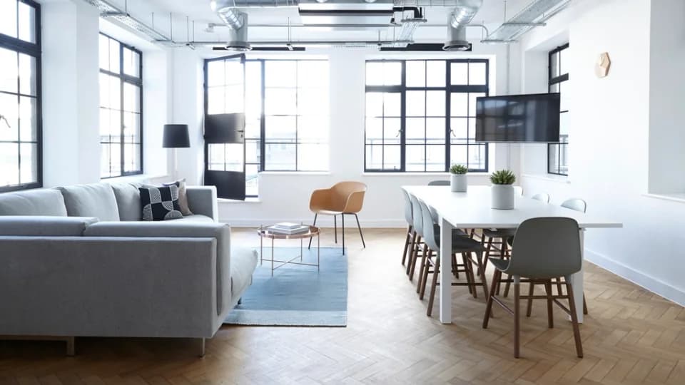 Espace de travail partagé lumineux, canapé et grande table de réunion
